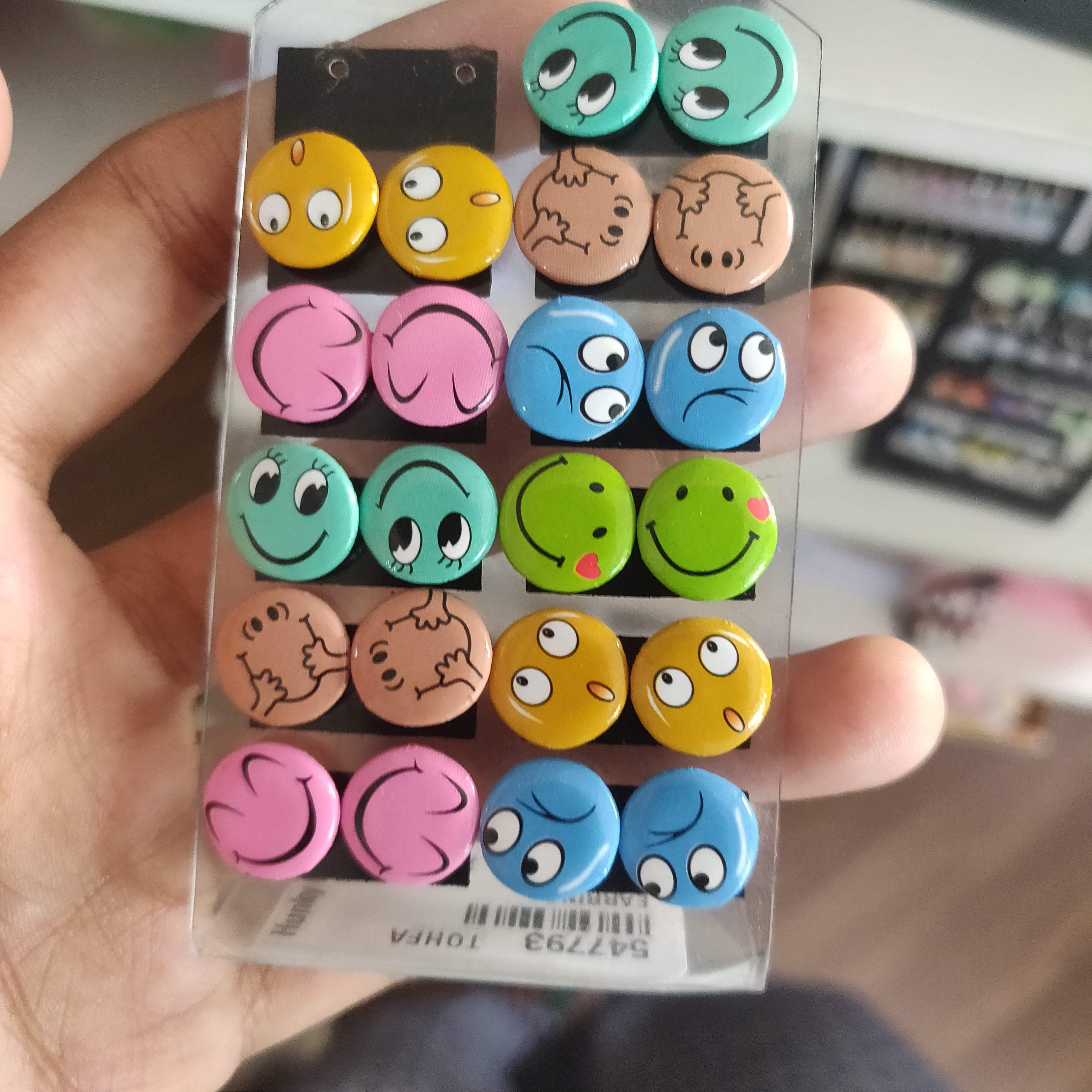 Facial expression,Smile,Button,Smiley,Emoticon,Font,Fashion accessory,Circle,Eraser,Nail