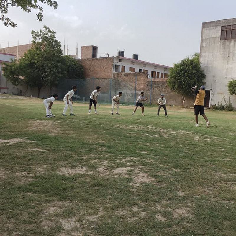 Sky,Grass,Sport venue,Team sport,Player,Cloud,Football,Cricket,Team,Campus