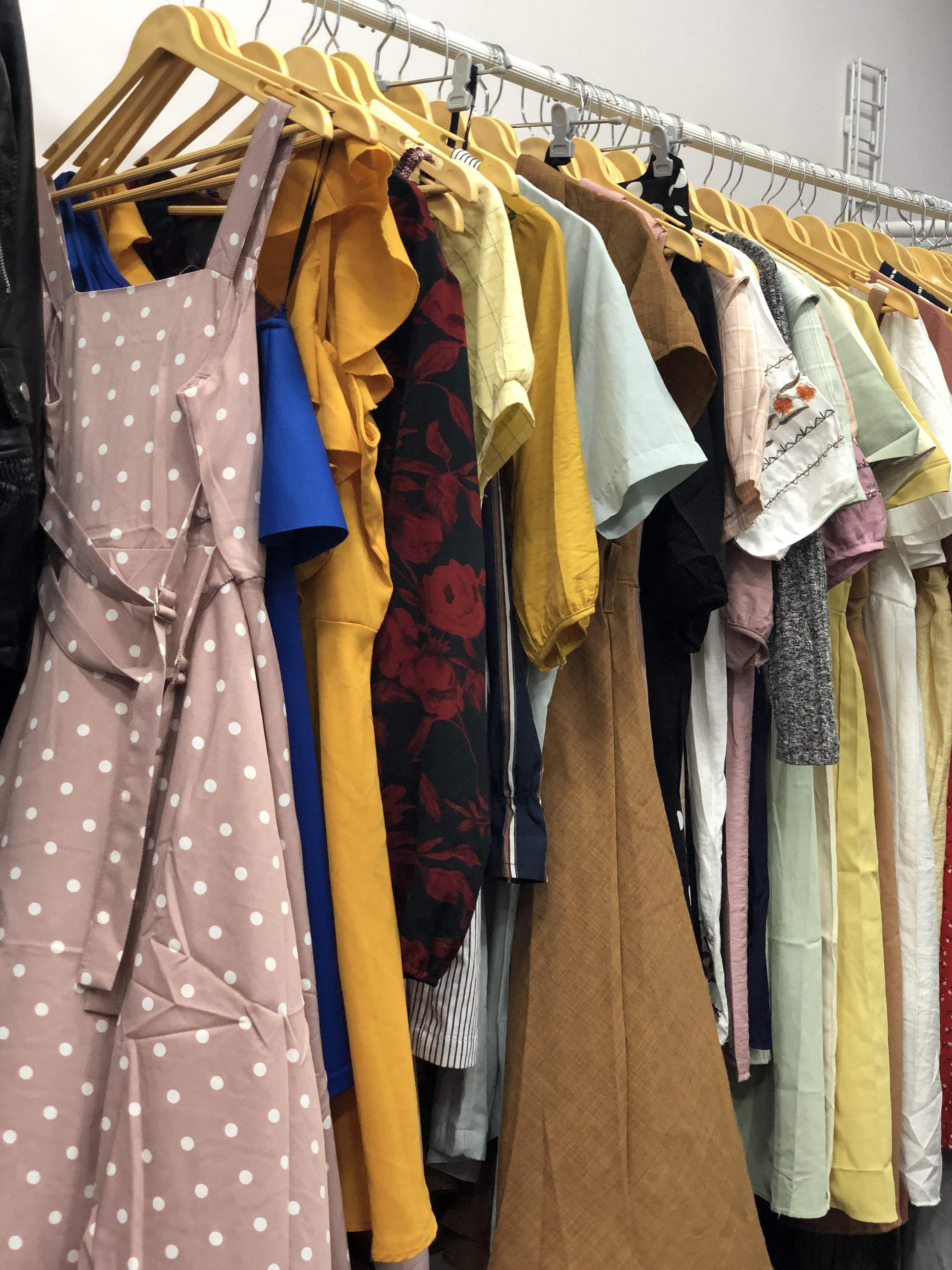 Clothes hanger,Clothing,Boutique,Yellow,Room,Outerwear,Textile,Dress,Fashion design,Costume design