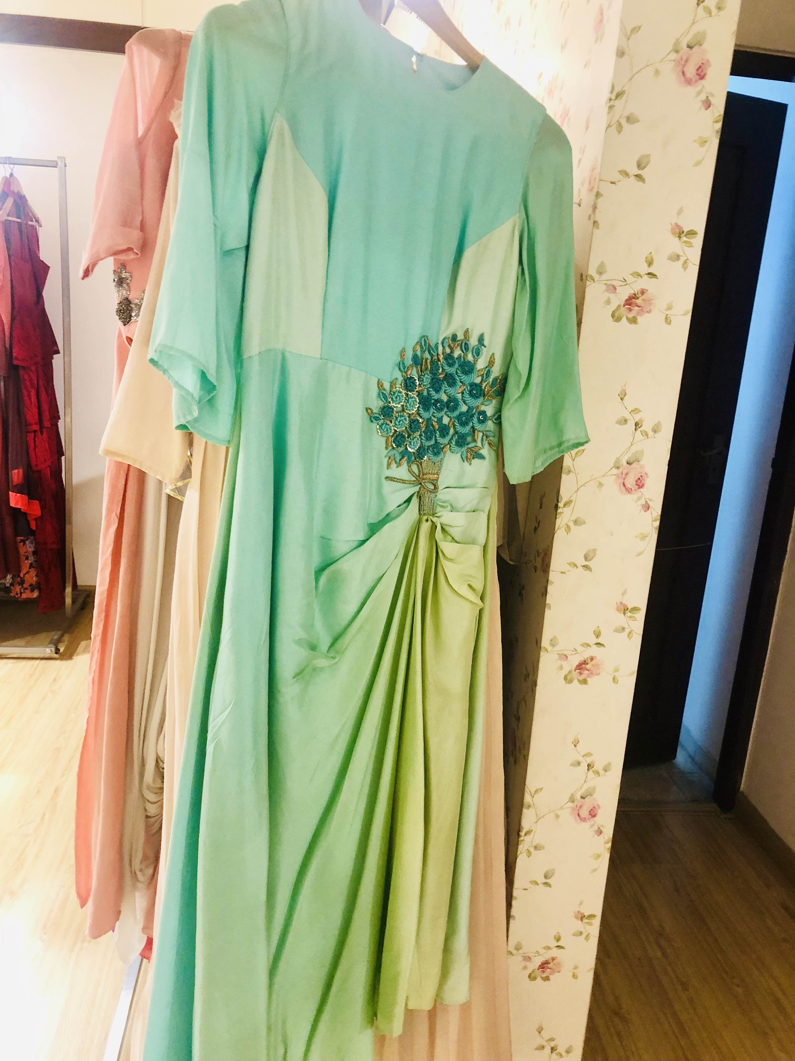 Clothing,Green,Dress,Formal wear,Boutique,Fashion design,Shoulder,Room,Outerwear,Textile