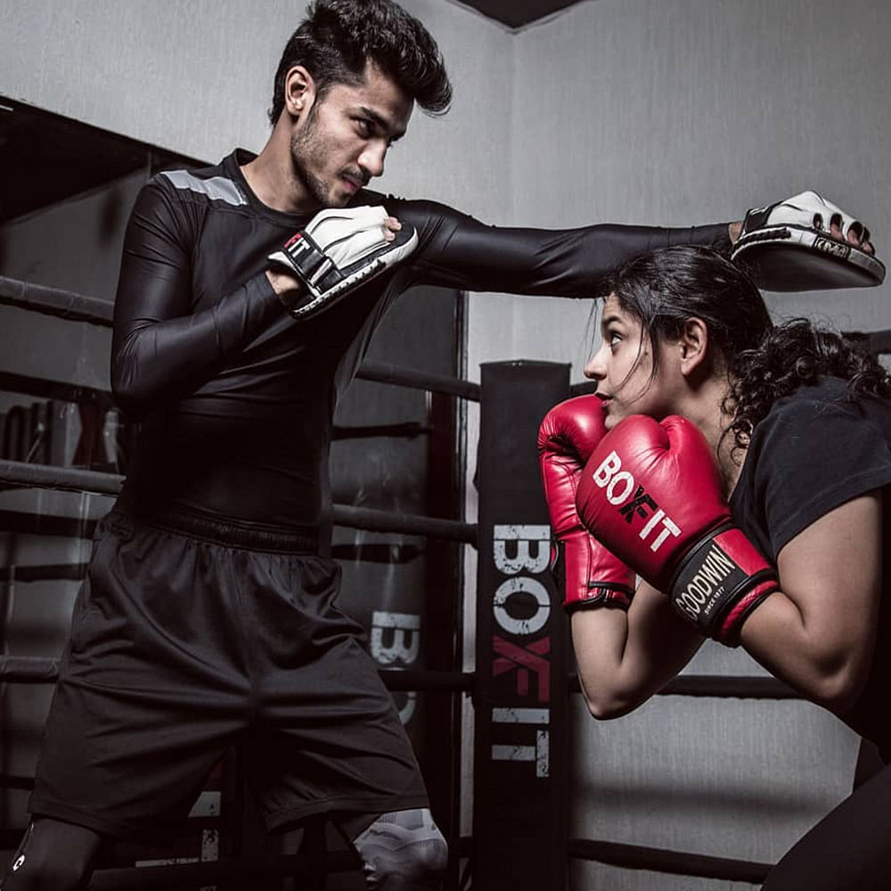 Boxing glove,Boxing,Muscle,Photo shoot,Contact sport,Boxing ring,Striking combat sports,Sport venue,Room,Professional boxer