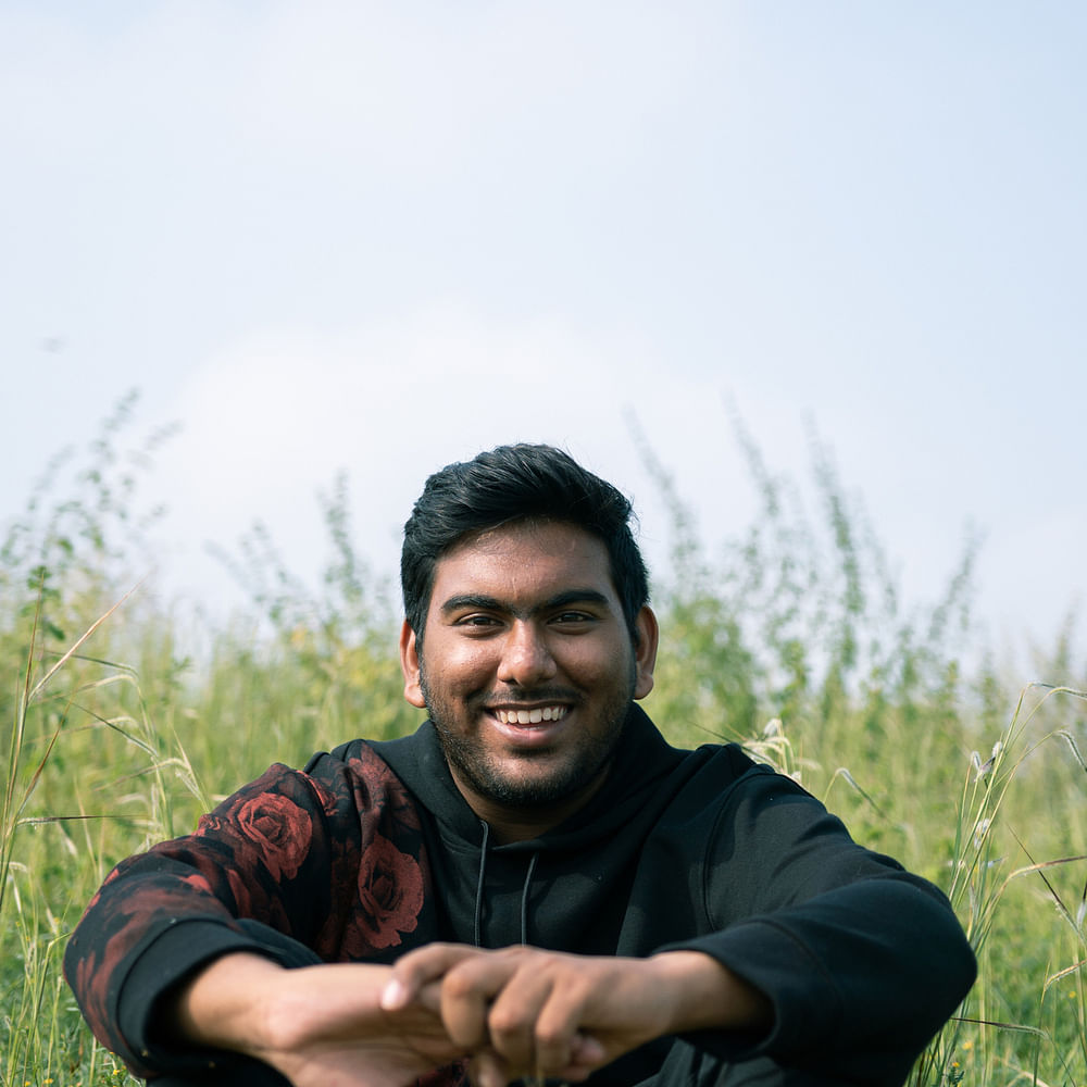 People in nature,Facial expression,Grass,Sitting,Smile,Grassland,Grass family,Photography,Cool,Human