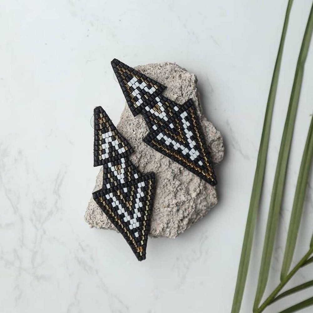 Leaf,Triangle,Fashion accessory,Font,Diamond,Ornament,Jewellery,Metal,Plant,Brooch