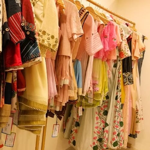 Clothes hanger,Clothing,Room,Boutique,Yellow,Closet,Textile,Peach,Dress,Furniture