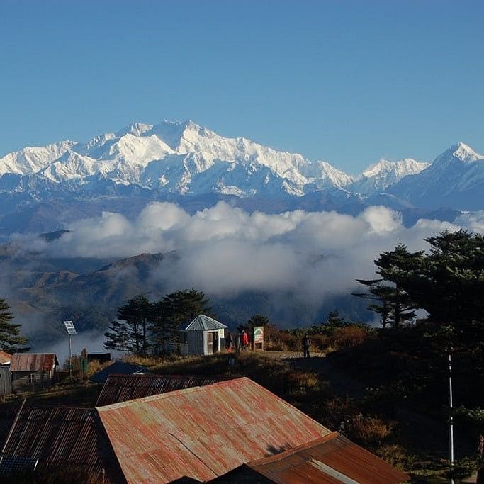 Mountainous landforms,Sky,Mountain range,Tree,Roof,Mountain,Highland,Hill station,Ridge,Summit