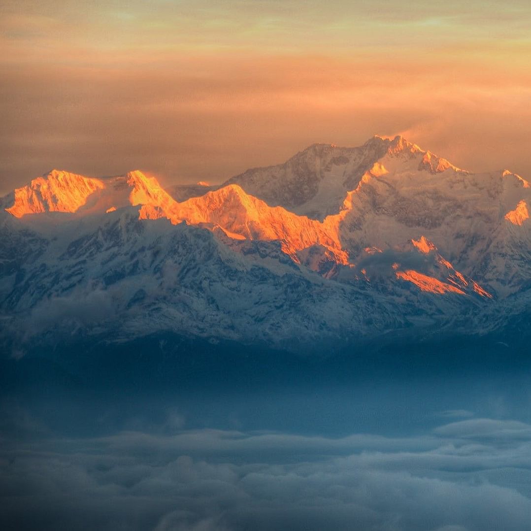 Sky,Mountainous landforms,Cloud,Mountain range,Atmosphere,Summit,Ridge,Amber,Mountain,Atmospheric phenomenon