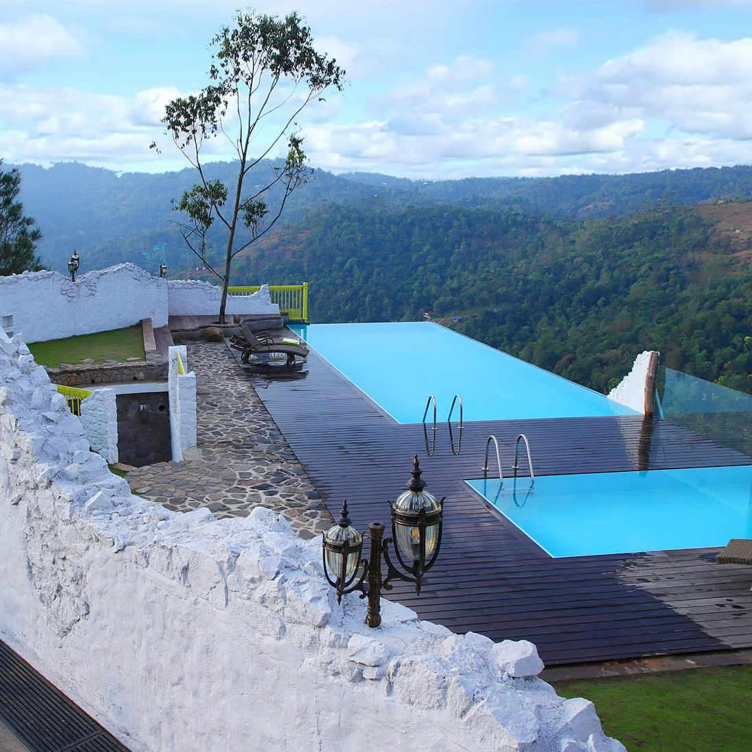 Sky,Cloud,Mountain,Tree,Table,Outdoor furniture,Slope,Shade,Landscape,Mountainous landforms