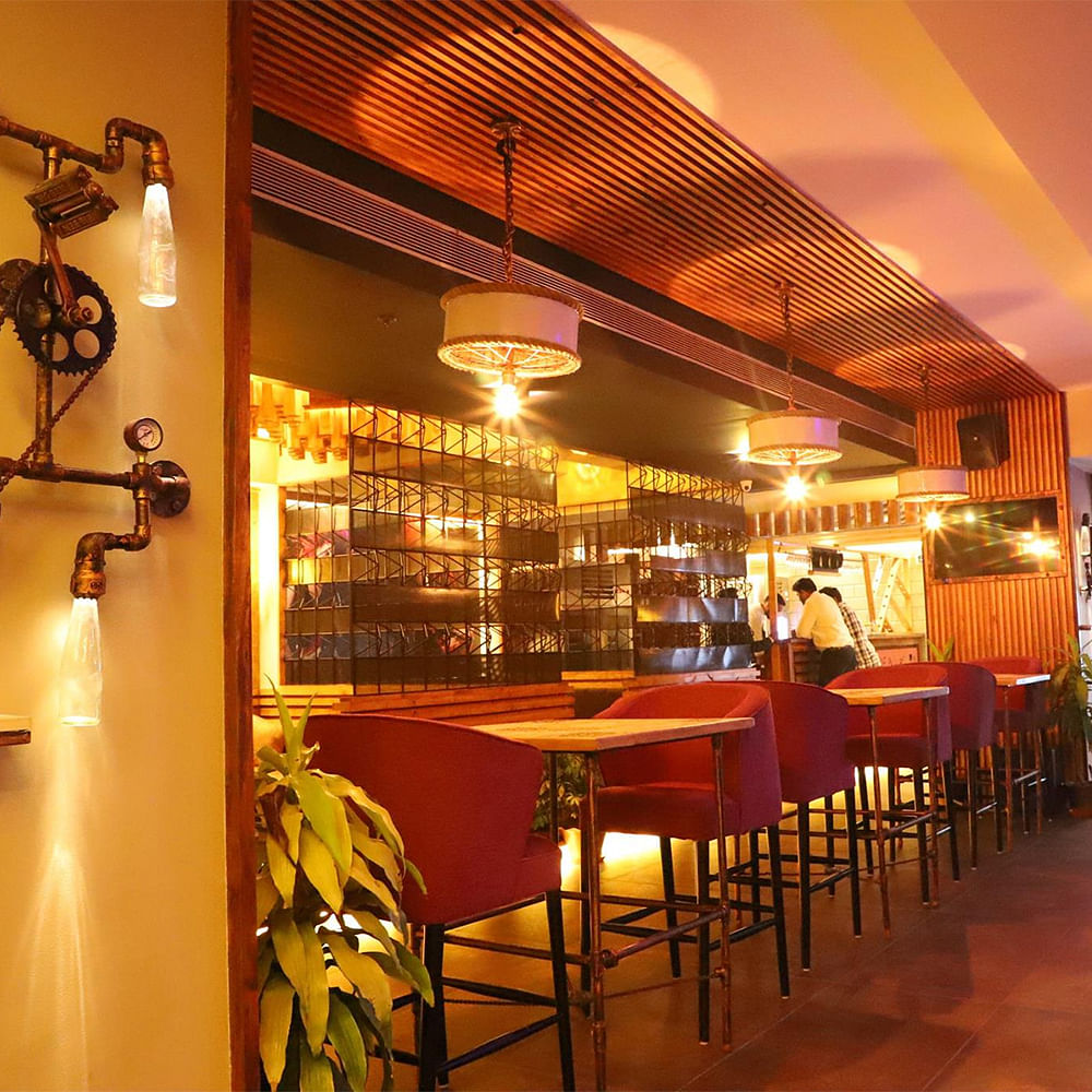 Drinking establishment,Lighting,Orange,Barware,Shelf,Amber,Table,Ceiling,Chair,Tavern