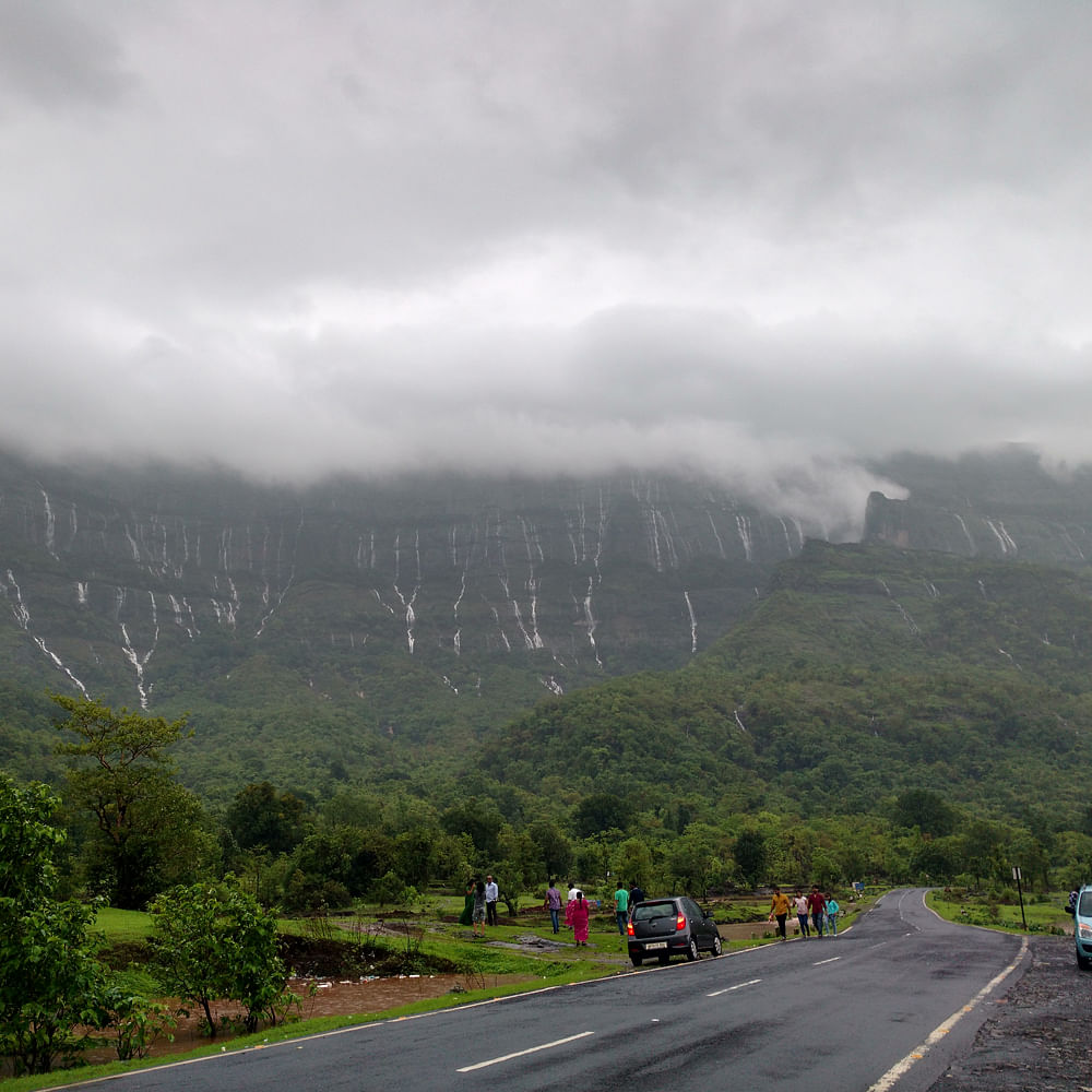 Cloud,Sky,Car,Mountain,Plant,Ecoregion,Vehicle,Infrastructure,Natural landscape,Highland