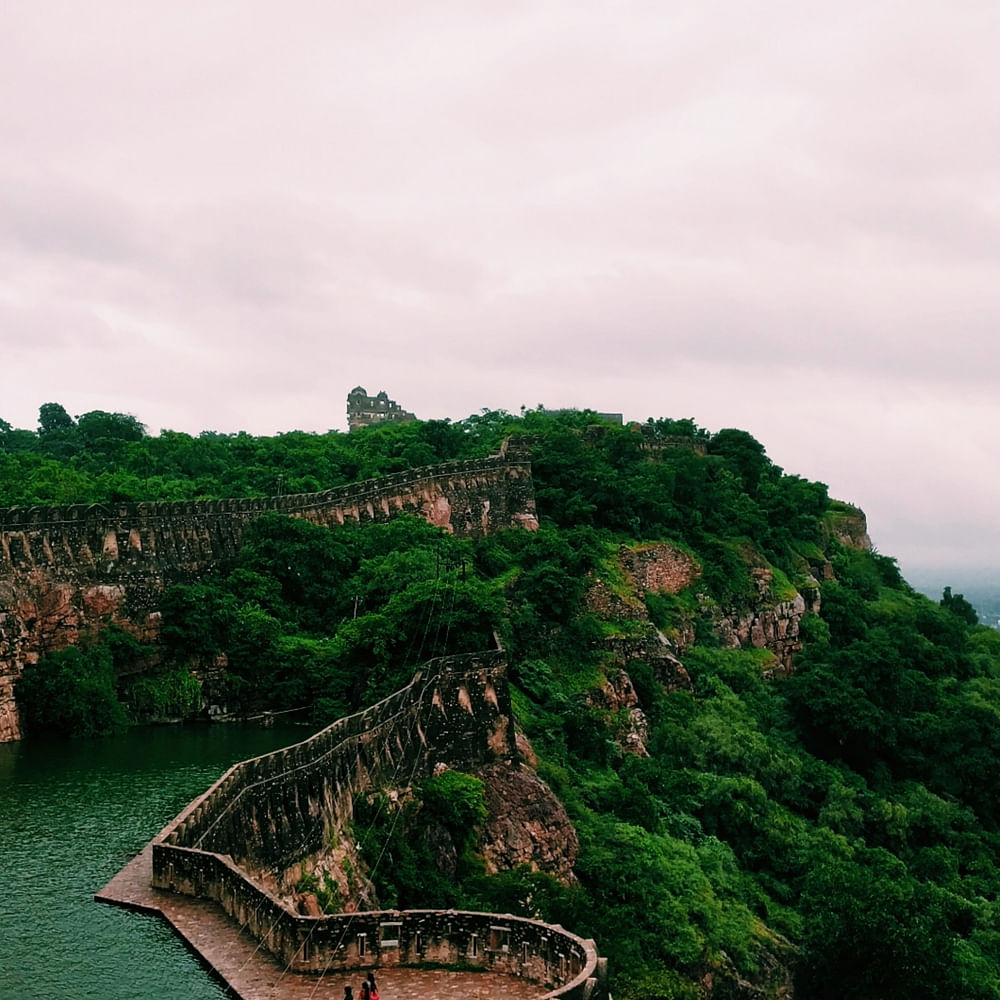 Sky,Cloud,Water,Tree,Natural landscape,Plant,Vegetation,Highland,Coastal and oceanic landforms,Building