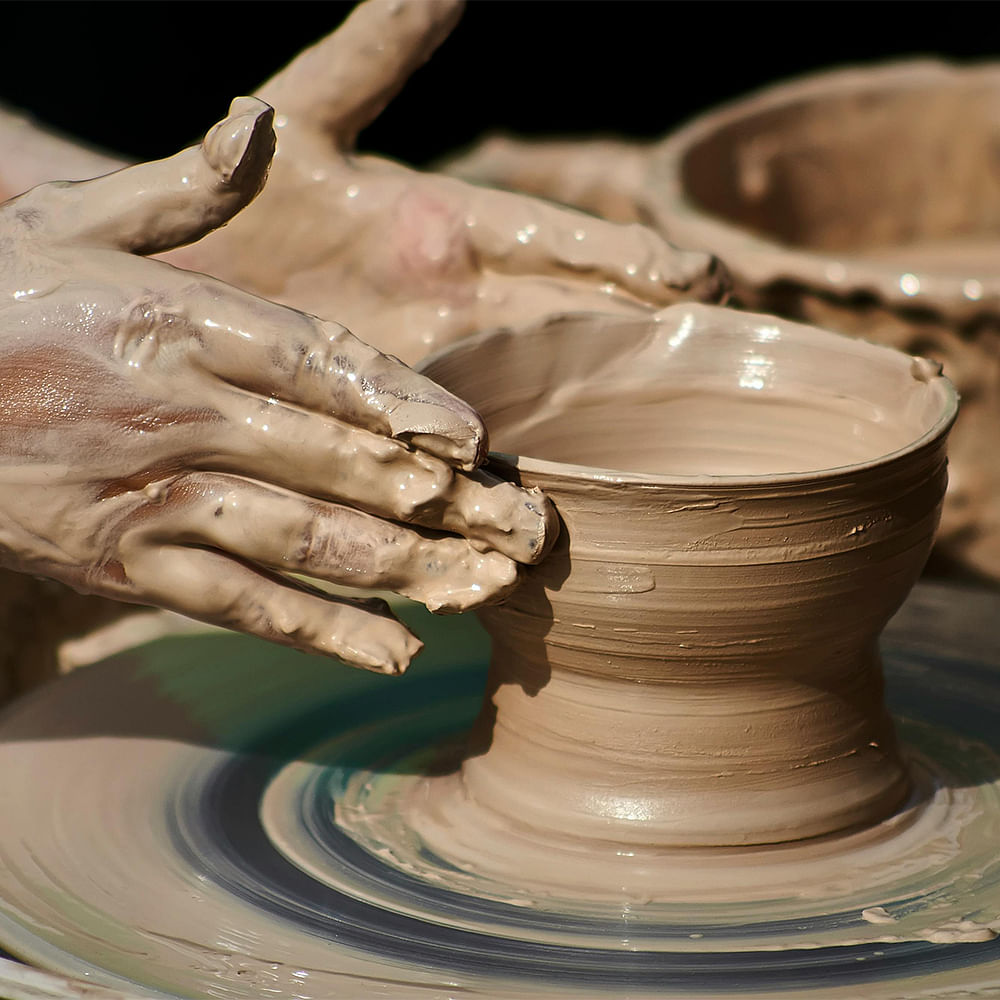 Potter's wheel,Wheel,Clay,Gesture,Serveware,Creative arts,Artisan,Pottery,Wood,Art