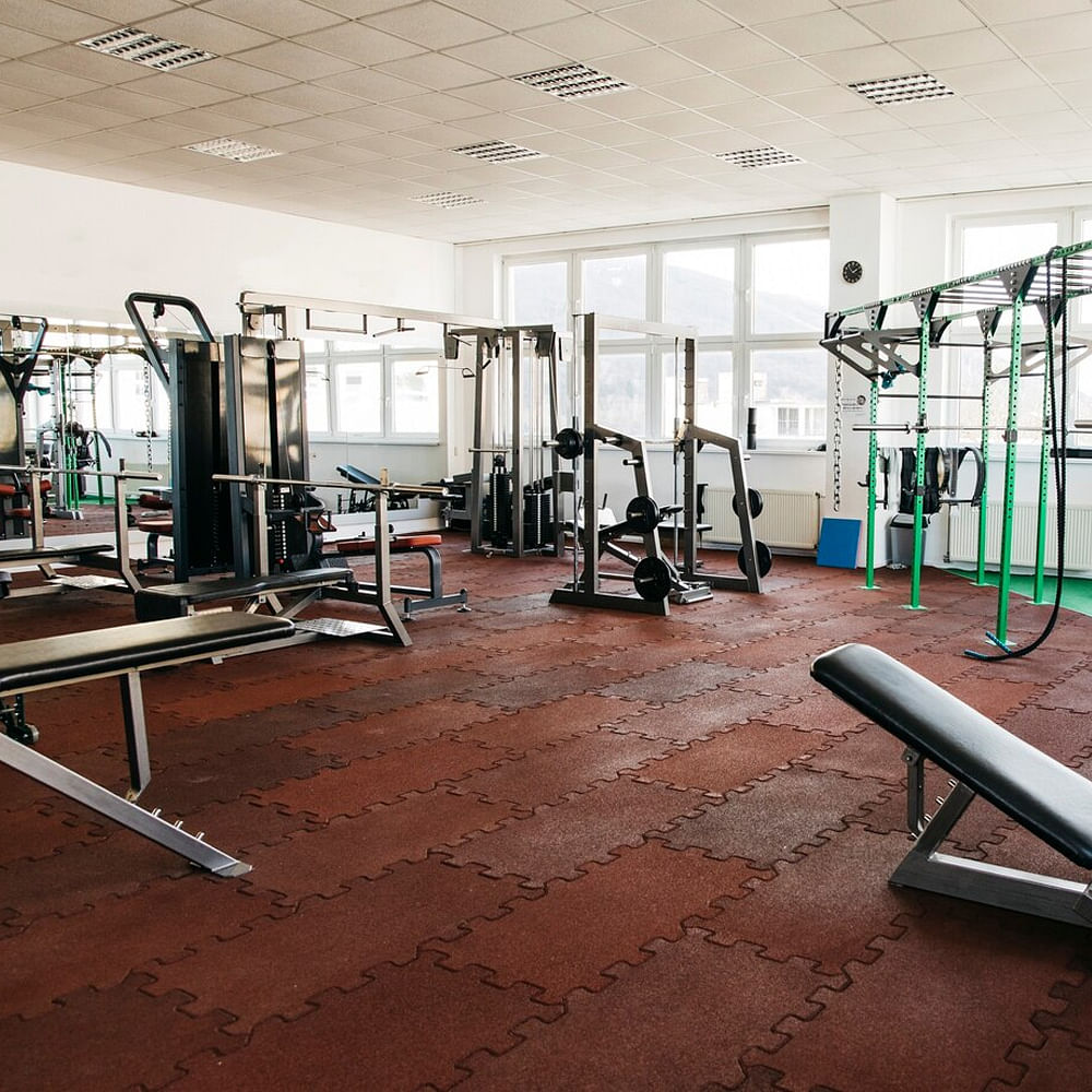 Flooring,Exercise equipment,Floor,Gym,Exercise machine,Ceiling,Wood flooring,Hardwood,Hall,Weightlifting Machine