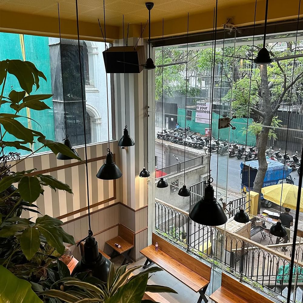 Interior design,Restaurant,Ceiling,Light fixture,Glass,Chair,Shade,Houseplant,Kitchen & Dining Room Table,Cafeteria