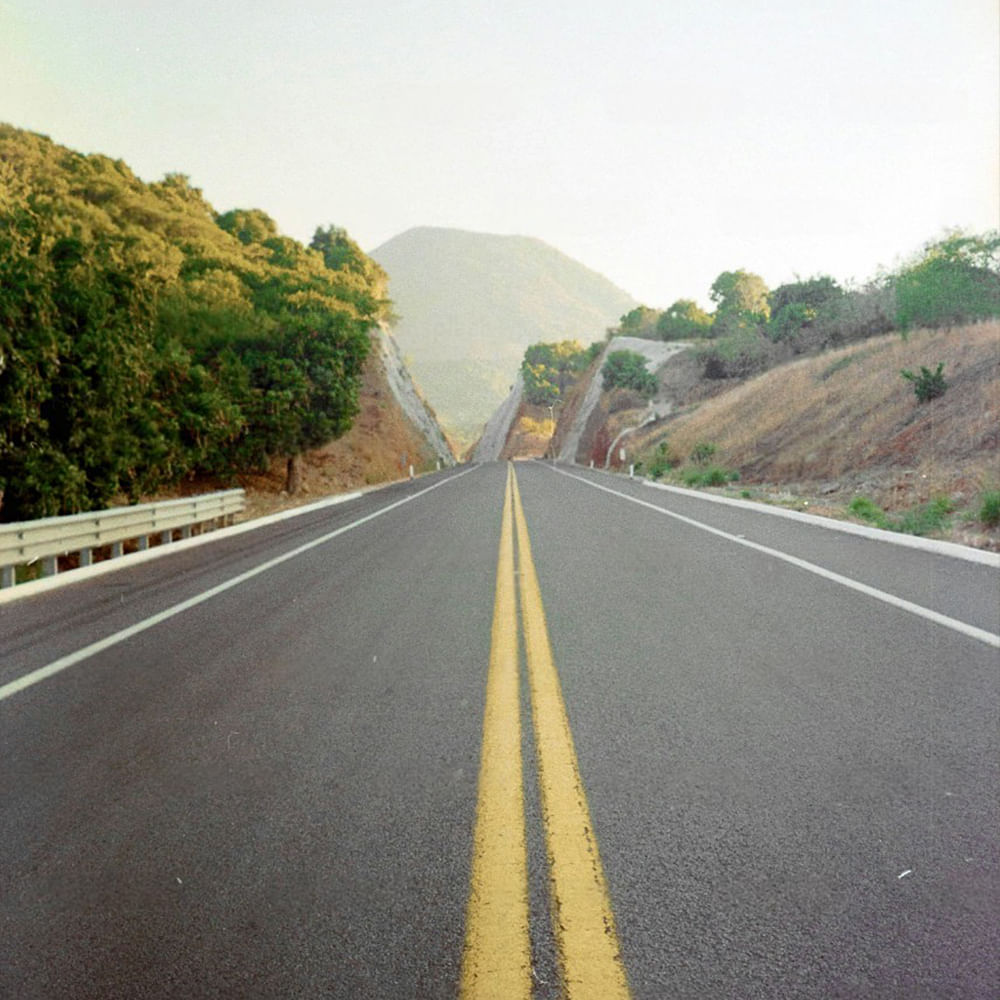 Road,Mode of transport,Road surface,Highway,Thoroughfare,Natural landscape,Asphalt,Yellow,Controlled-access highway,Hill