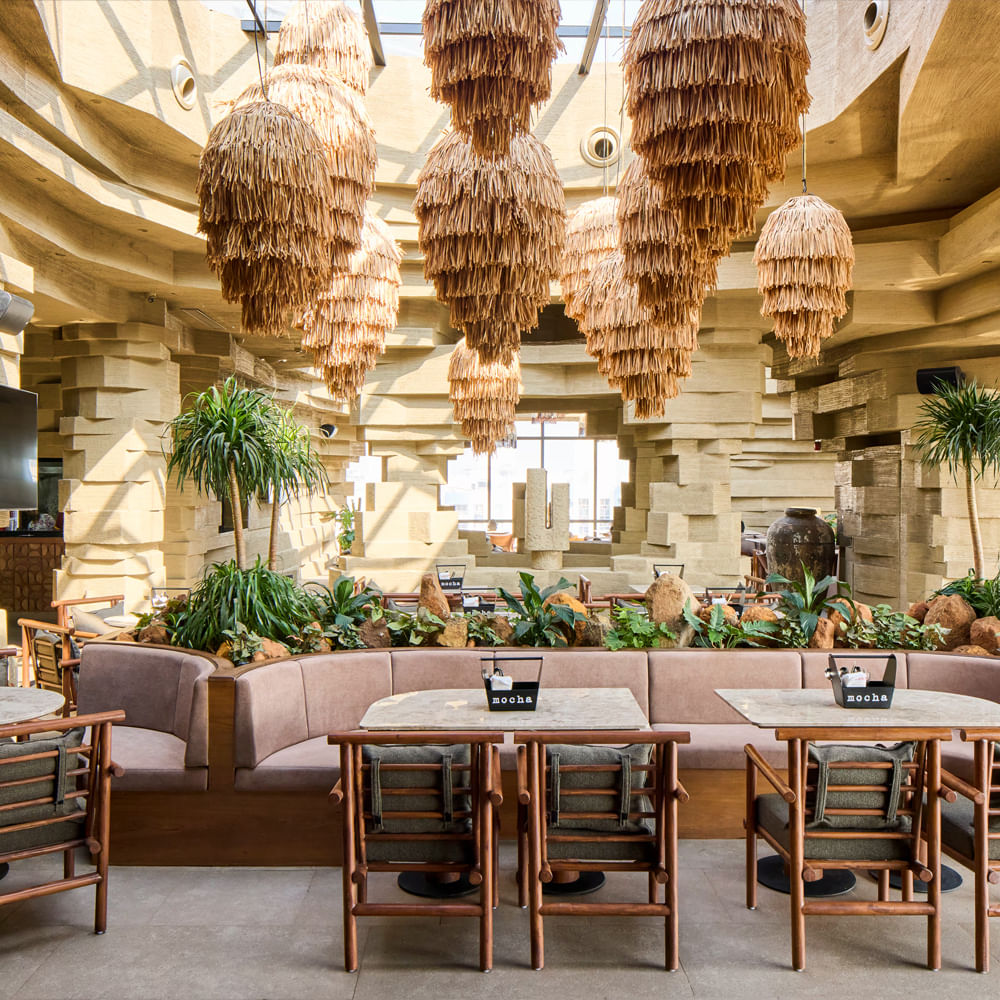 Interior design,Ceiling,Light fixture,Restaurant,Natural material,Chandelier,Lobby,Design,Chair,Houseplant