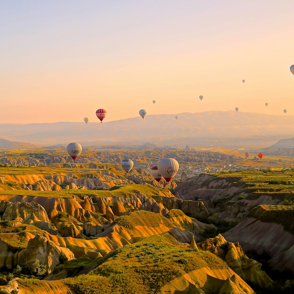 Hot air ballooning,Hot air balloon,Balloon,Air sports,Aerostat,Horizon,Ecoregion,Terrain,Geological formation,Air travel